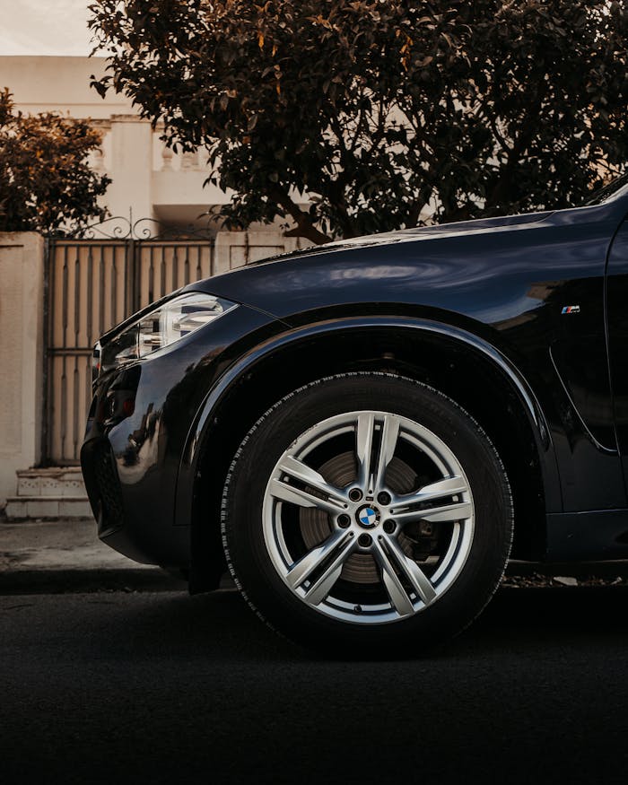 Close-up of a black luxury car parked on a street in Nabeul, Tunisia, showcasing its sleek design and shiny exterior.